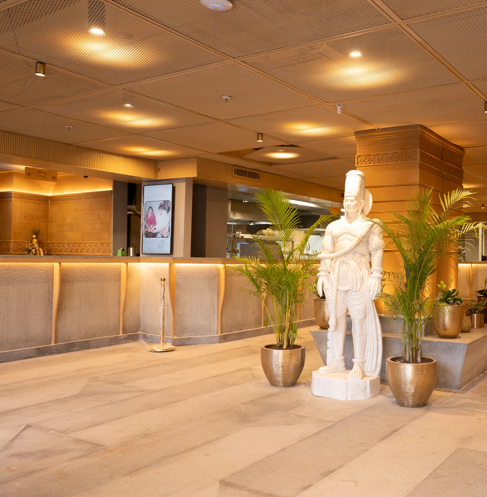 Reception lobby with white statue and planters — Chalukya Samrat